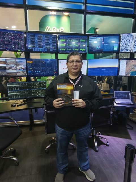 Víctor en una sala de control de operaciones con su libro