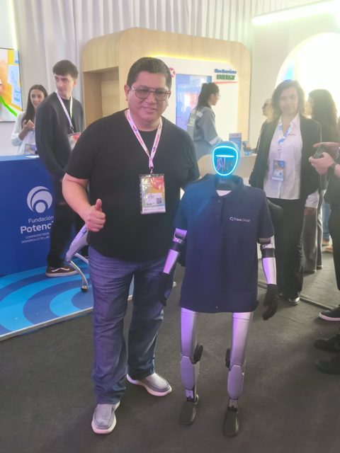 Víctor junto a un robot humanoide en una feria de energía